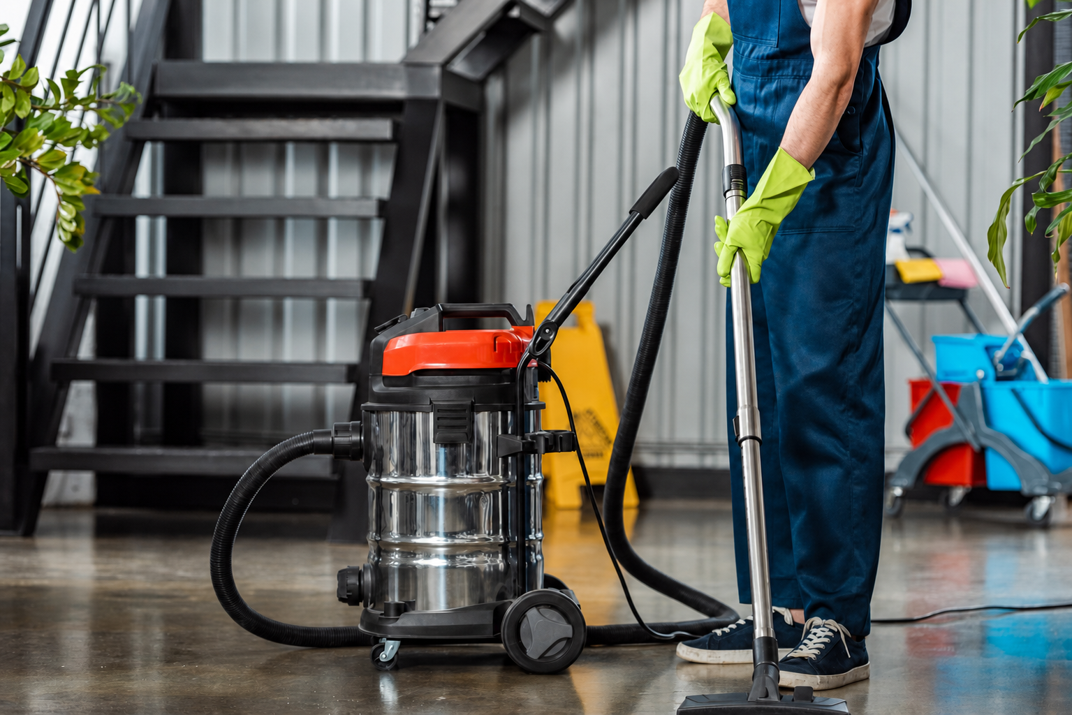 Agent d’entretien utilisant aspirateur industriel sur sol